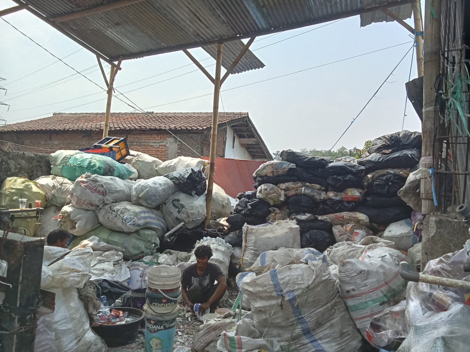 Pekerja memilah karung material di area sortasi
